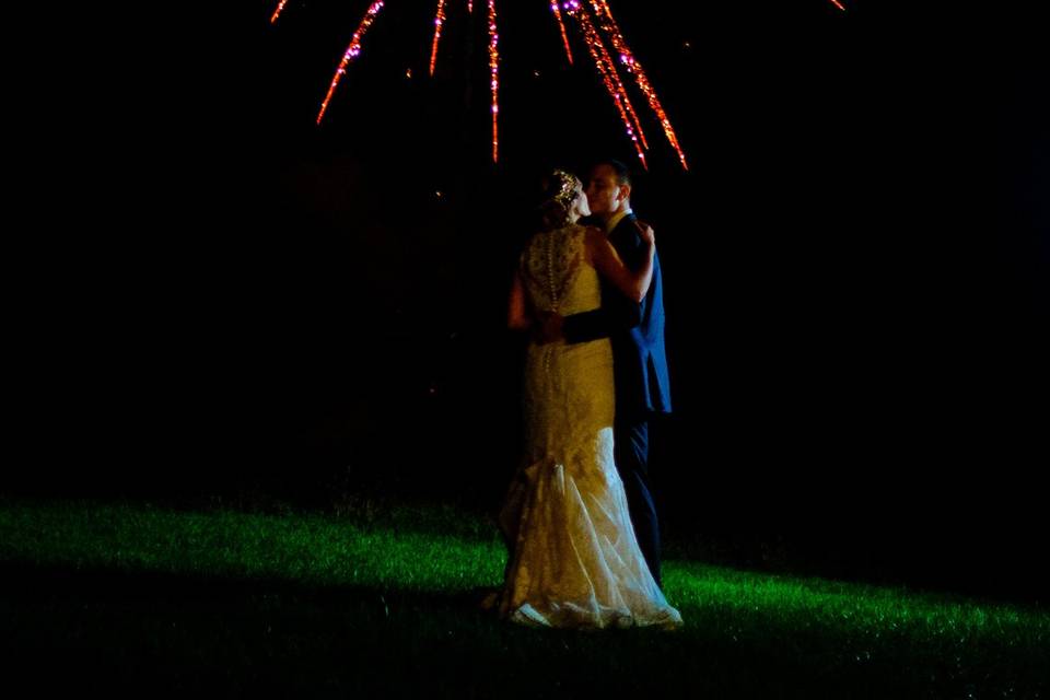 Newlyweds kissing under the fireworks