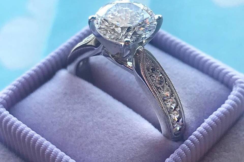 Classic round diamond with side accent diamonds in our vintage lavender heriloom box