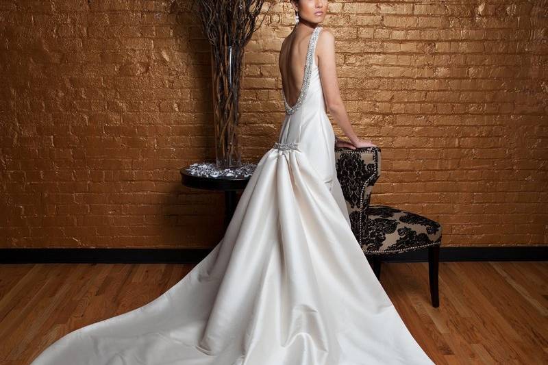 JackyMikado.  Trumpet gown with detachable cathedral length train.  Bateau neckline with plunging back neckline, and accented with swaroski crystal beaded trim.
