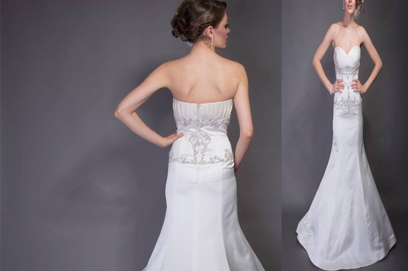 Style “Emma”Silk Organza.  Dropped waist slim strapless A-line gown with box pleats.  Ruched neckline band detail at bust line and dropped waist line.  Gown is accented with bias cut floral detail and crystals at drop waist and train.
