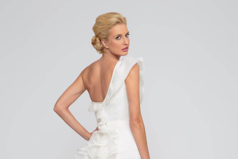 Juno  Satin Organza.  Trumpet gown with natural waist line.  One shoulder neckline with ruffled detail that crosses the bodice and extends into the one shoulder and continues down the back of the chapel length train.