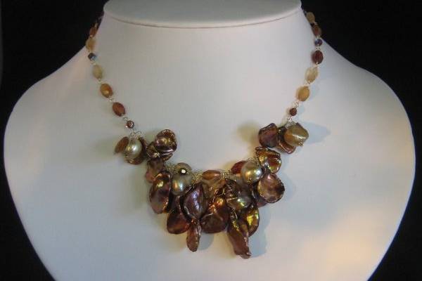 CHAROLETTE/$210.-  Another one of our favorites!  Beautiful shades of brown hessonite garnet create an ombre pattern.  Set against the textural warm, coppery colored brown keishi pearls and touches of crystal, this necklace makes a perfect tonal statement.  Goldtone clasp-17