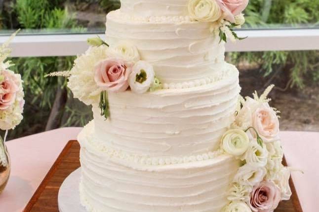 White wedding cake with soft colored flowers