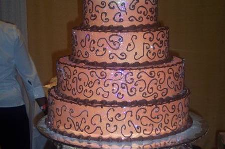 5 tier peach colored wedding cake with chocolate scrolls.