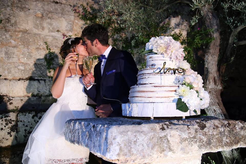 Couple kissing by their cake