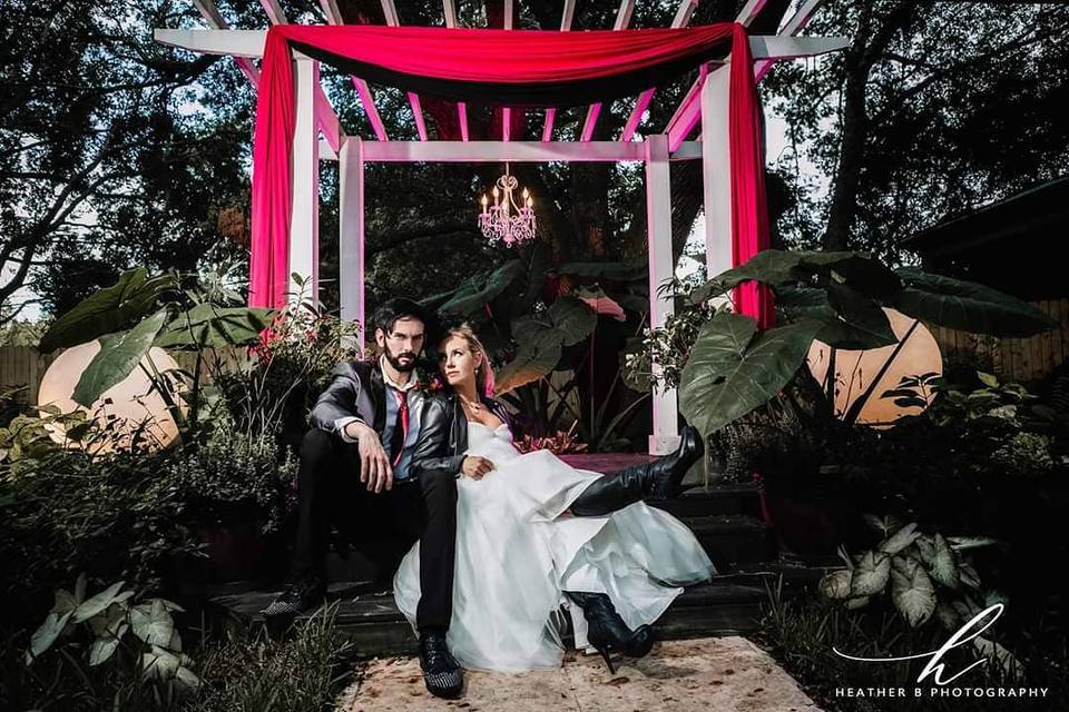 Newlyweds sitting by the wedding arbor