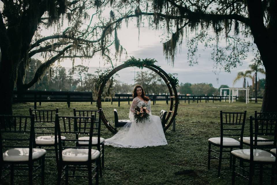 Bride sitting by the circle arch