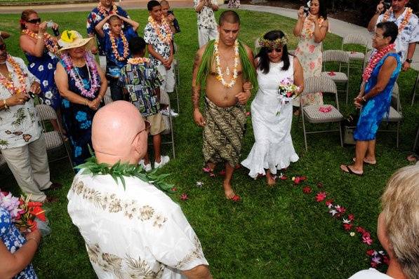 Bride's son walking her down in traditional Hawaiian dress