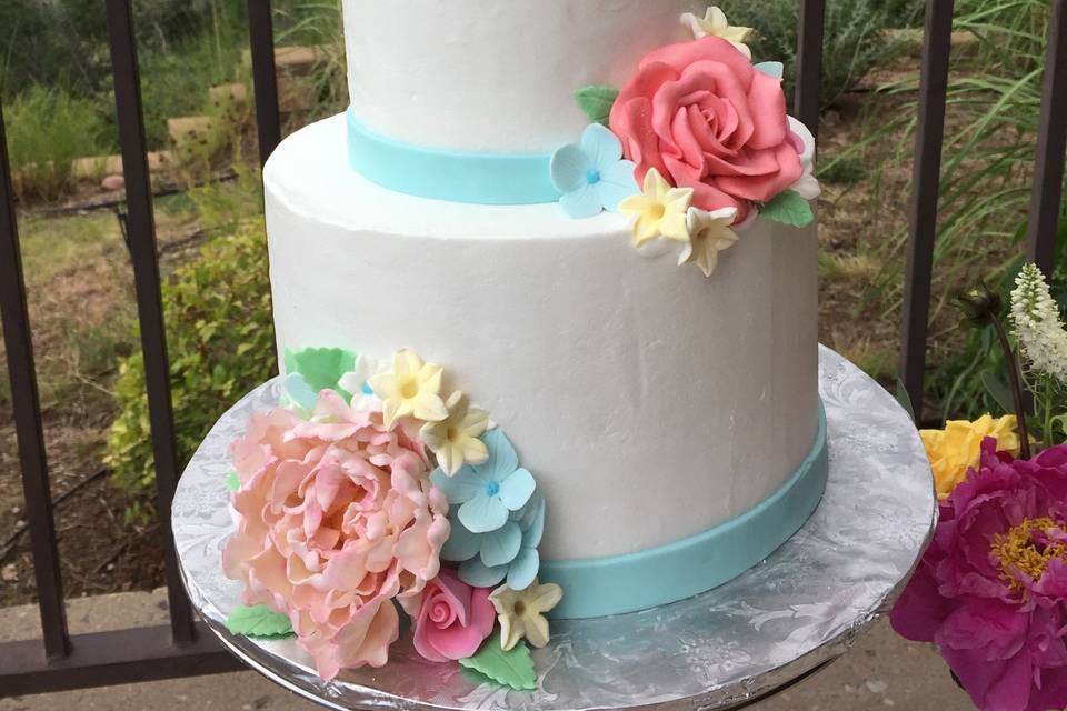 Wedding cake with black ribbon and purple flowers