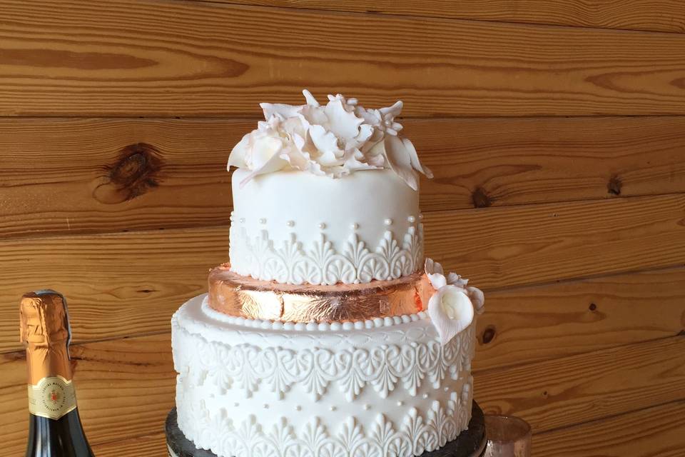 White wedding cake with gold ribbon