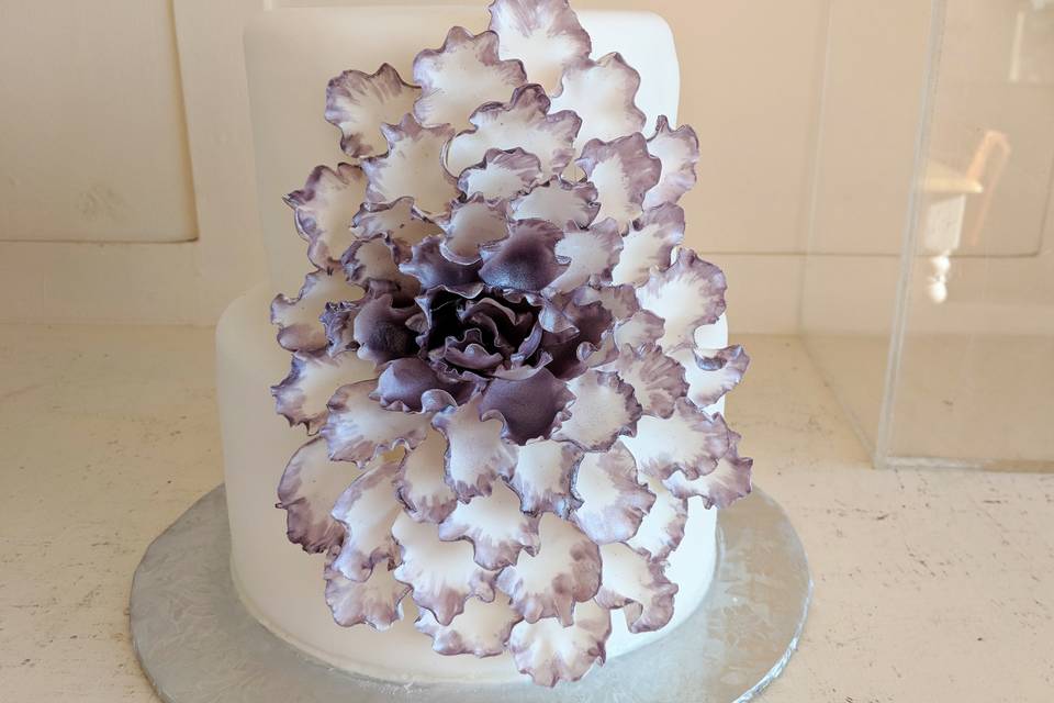 White wedding cake with purple flower