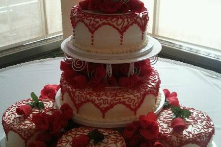 Red & White Tiered Cake with 3 satellite cakes.  Made to look like doilies over tops of cakes with roses between layers.