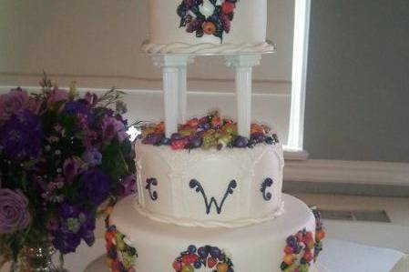 Lovely Tiered cake with fresh marzipan fruits adorning each layer.