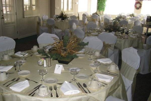 White Chair Covers with Gold Organza Sashes and Gold Organza Overlays