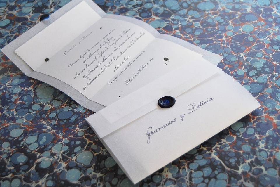 Imperium style
Invitation designed by Sandra Márquez. White stone parchment paper of 165 grams is used for the exterior, the interior is made of 100 grams golden dust paper from the Curious series. The invitation is the envelope, also.  Wax sealed in overseas blue color. Size 20x31 cm.