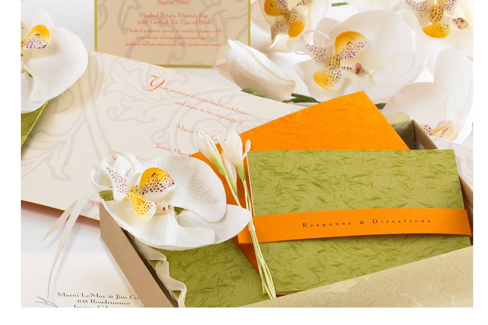 Garden Wedding: The bride’s flowers and colors inspired a lush floral motif, featuring paper orchids, white accent blooms, vintage graphics and woven silk ribbon. Handmade paper, ribbon binding and Japanese tissue wrap completed the exquisite presentation.