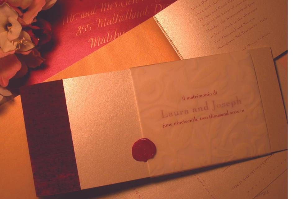 Il Matrimonio: A wedding in a medieval castle inspired a lushly romantic invitation that featured vintage etchings of the Italian countryside. Rich gold and ivory stock is bound in beautiful book cloth and hand-stitched into a custom booklet. Finishing touches include a vellum slip band, red sealing wax and a button-and-string envelope addressed with gold calligraphy.