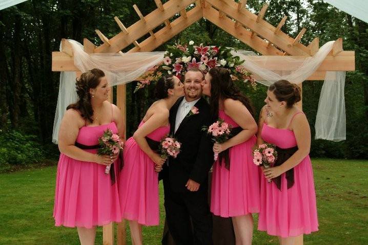 Bridesmaids kissing the groom on the cheek