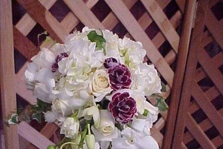 cascading bridal bk . Orchids, roses, sweetheart roses, burgundy mini carns. A very refined , feminine bridal bk.