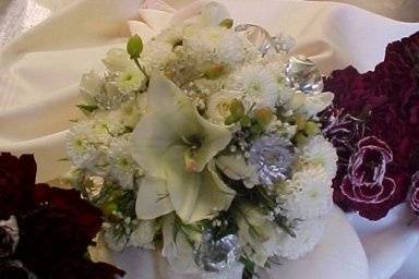 ivory lilies, roses, lisianthus make a personal  hand tied masterpiece bk.