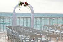 Pool deck wedding set up. Simple elegant arch that was catching the wind perfectly. Chairs were lined up with rose petals on the floor to guide the bride to her groom. Beautiful colors of the sky for this day wedding that overlooked the ocean and the different hues of blue.