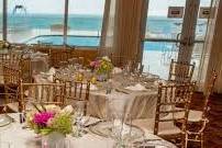 The wedding happened outside on the pool deck that oversaw the beach and ocean waves. An intimate setting, for the reception, was inside the banquet hall. Table decorations incorporated gold elements to make a bold and elegant statement to compliment the bride and groom.