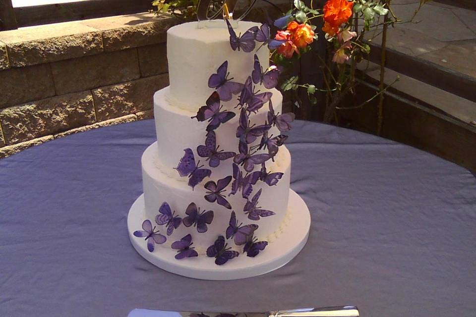 Buttercream tiered cake showing purple butterflies