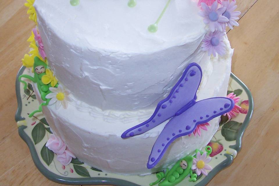 Baby shower cake displaying hand made sweet peas, butterflies and flowers that are all edible