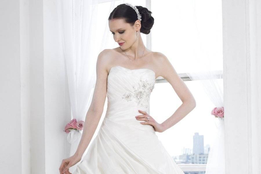 Style J6222 is a full A-line featuring taffeta and tulle. Beading and lace adorn the skirt and bodice.