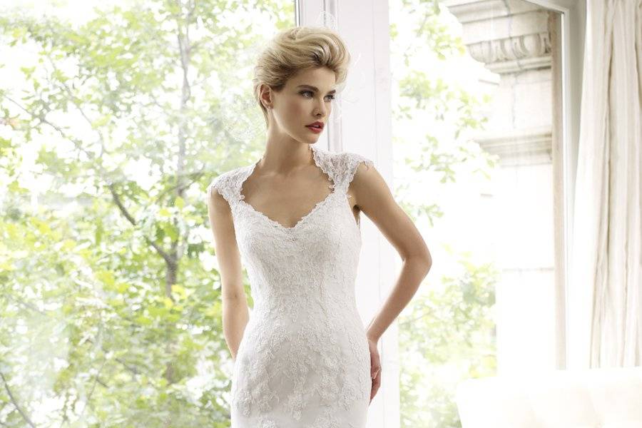 H1214This fit and flare sheath features delicate lace and Point d'esprit throughout. The all lace illusion back features a loops and button closure.