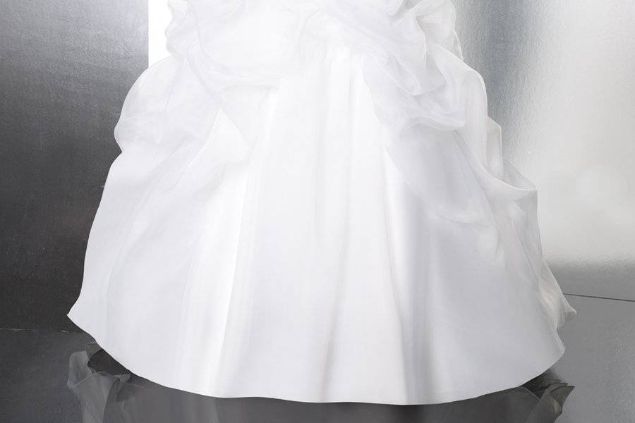 Style T580This organza ball gown features soft pick-ups throughout the skirt. Subtle beaded applique at the waist finish this look.