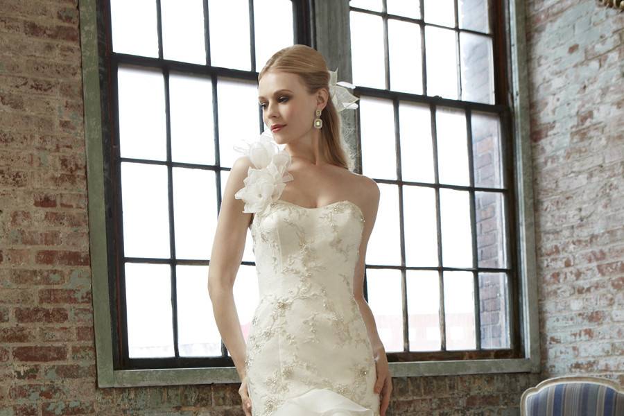 J 6277Fall 2013A soft organza and lace fit and flare that features cascading layers along the skirt. The bodice is embellished with Swarovski crystals and beads. Hand-crafted rosettes accent the one shoulder strap.