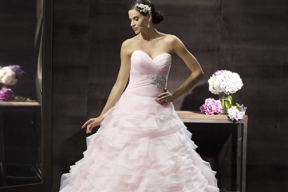 H1241Soft organza folds into layers on this dramatic and airy skirt. This ball gown features a flattering sweetheart neckline and ruched bodice with a Swarovski beaded medallion. A half corset closure ties this look together.