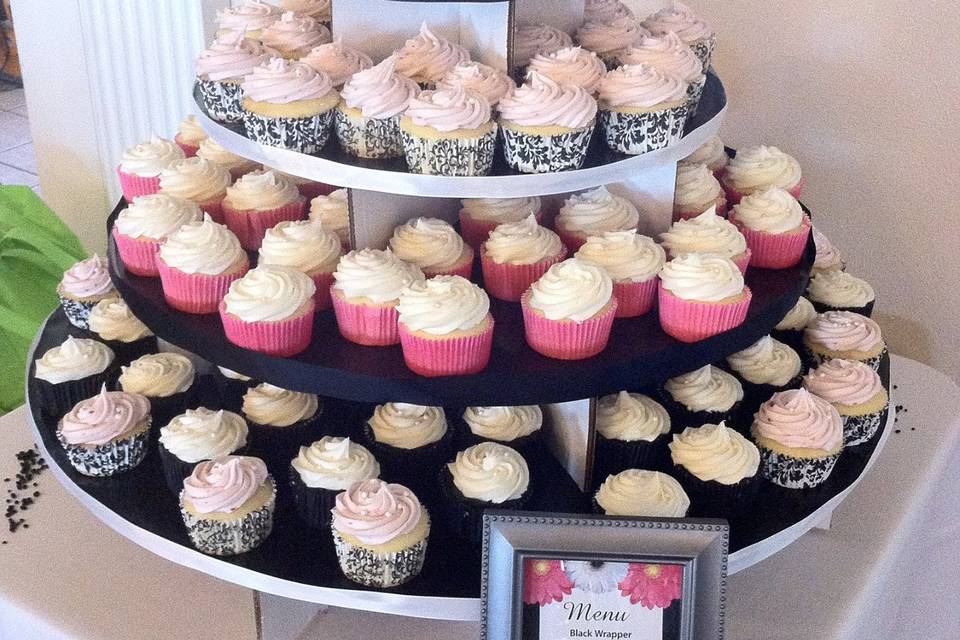 Cupcake tower with complementing mini-cake for the bride and groom to cut.