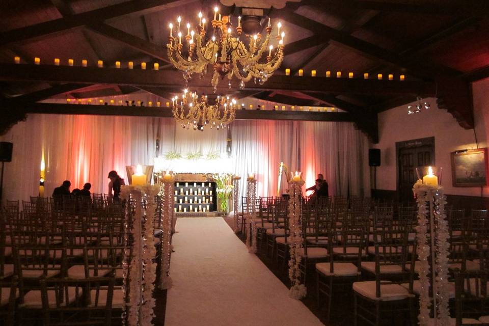 In the great room at ponte vedra inn the beams were lit with led pillar candles, the chandeliers encrusted with strands of hand strung dendrobium orchids, the aisle markers strands of crystals and orchids and the ceremony site infront of the fireplace embellished with a mantle of phalenopsis orchids and fire place filled with candles.