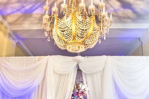 At the end of the grande hall an ante room was created. Guest's escort cards were received at the base of a flourish of flowers. The lighting of the hall enhanced the chandeliers making their crystals dance in the flood of light.