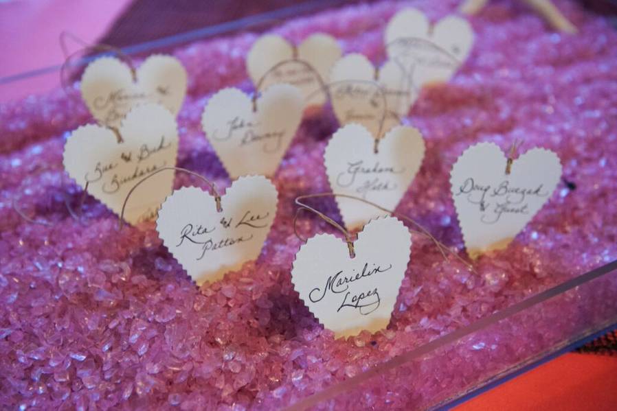 Guest name tags nestled in pink crushed glass