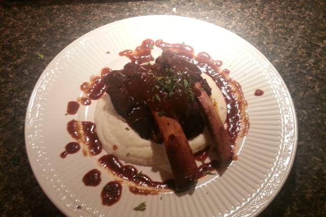 Braised beef rib with red wine barbecue sauce on a bed of pureed roasted garlic cauliflower