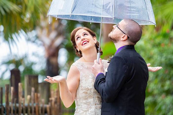 Bride and Groom pose in rain