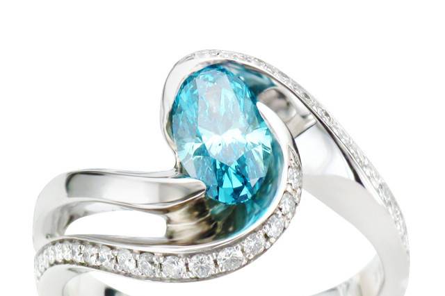 Custom Oval Blue Diamond Ring with white diamond accents in Brilliance by Mark Schneider