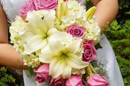 A cascade bouquet of ivory roses, hydrangeas, lilies and lavender roses.