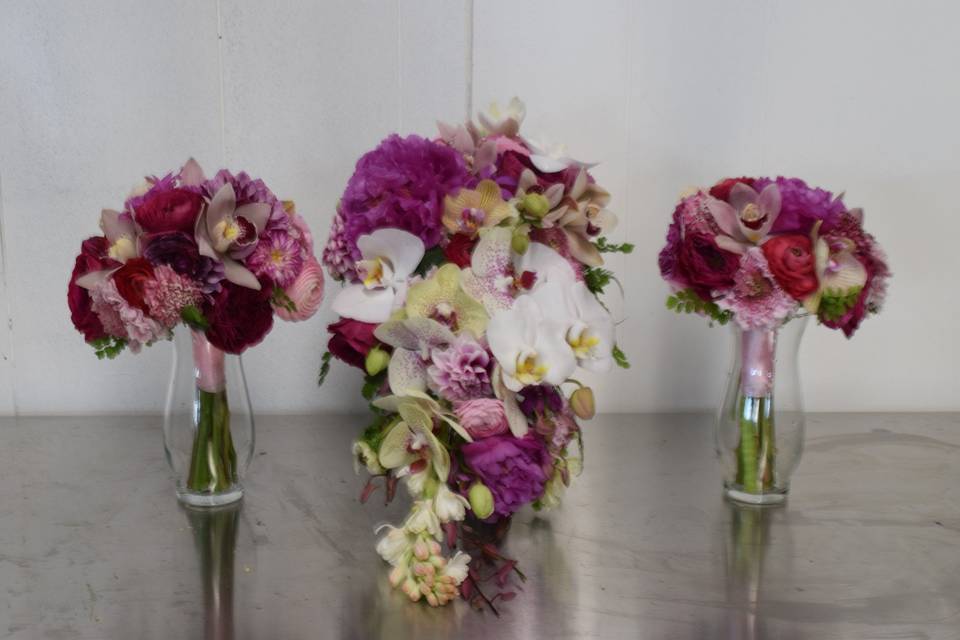 A cascade style bridal bouquet with two bridesmaids bouquets