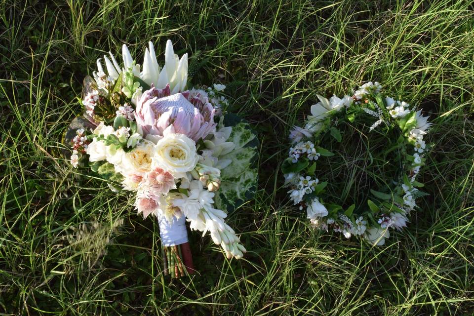A cascade style bridal bouquet next to the bridal flower crown.