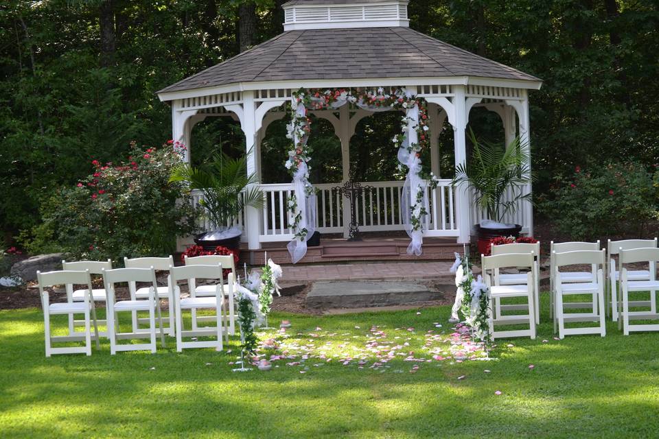 gazebo ceremony garden with white wooden chairs set up for small group