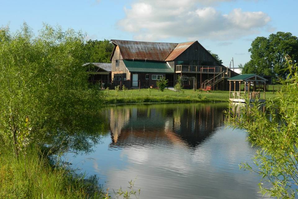 Looking north from the south side of the ranch pond. At the left is the West Work Barn, then the Corn Crib with the new Pond Pavilion on its south side, then the Wedding Barn/Events Center. To the far right and in the distance is the Indoor Arena. Note the dock on the north edge of the pond at Westwoods' Civil War Ranch.