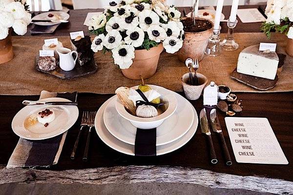 Close up of place setting {pear, cheese wrapped in cheese cloth and tied with a black ribbon. Cutlery was placed in miniature terracotta pots.