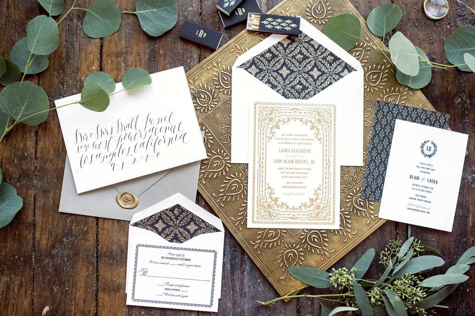 Hello Tenfold's Florentine wedding invitation suite features vintage-inspired frames, patterns, and a wreath monogram. We love how it looks in a black and gold color palette!