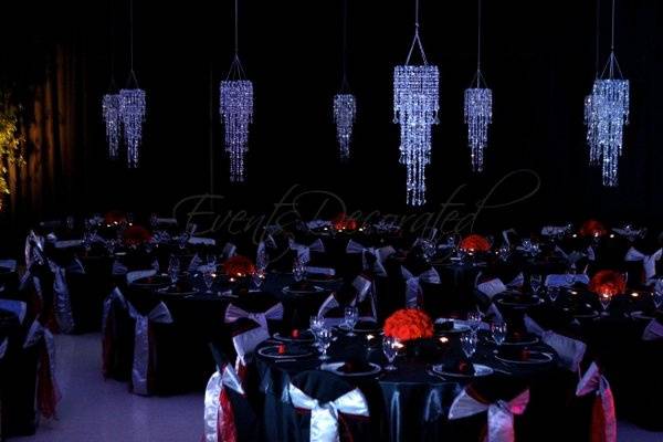 Events Decorated - Evening Formal Fundraising Event.  Black wall draping, crystal chandeliers, room lighting, table linens, chair covers and sashes, place settings, and red rose centerpieces.