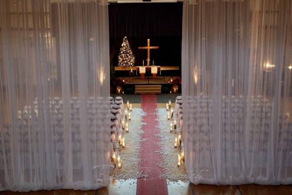 Events Decorated - December Wedding Ceremony.  Sheer white drape, chair covers and sashes, aisle runner, candle aisle markers, rose petals, rustic lanterns, birch trees, and live cypress trees at the altar.
