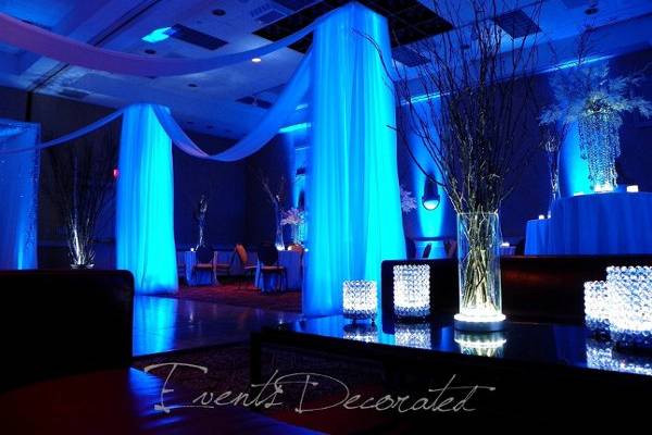 Events Decorated - Drape columns illuminated the dance floor, up lighting in blue, crystal accents used on all the tables
